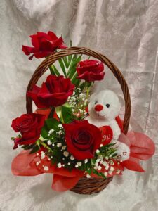 Centro de 5 rosas rojas en cesta con peluche de oso. Disponible y personalizable.